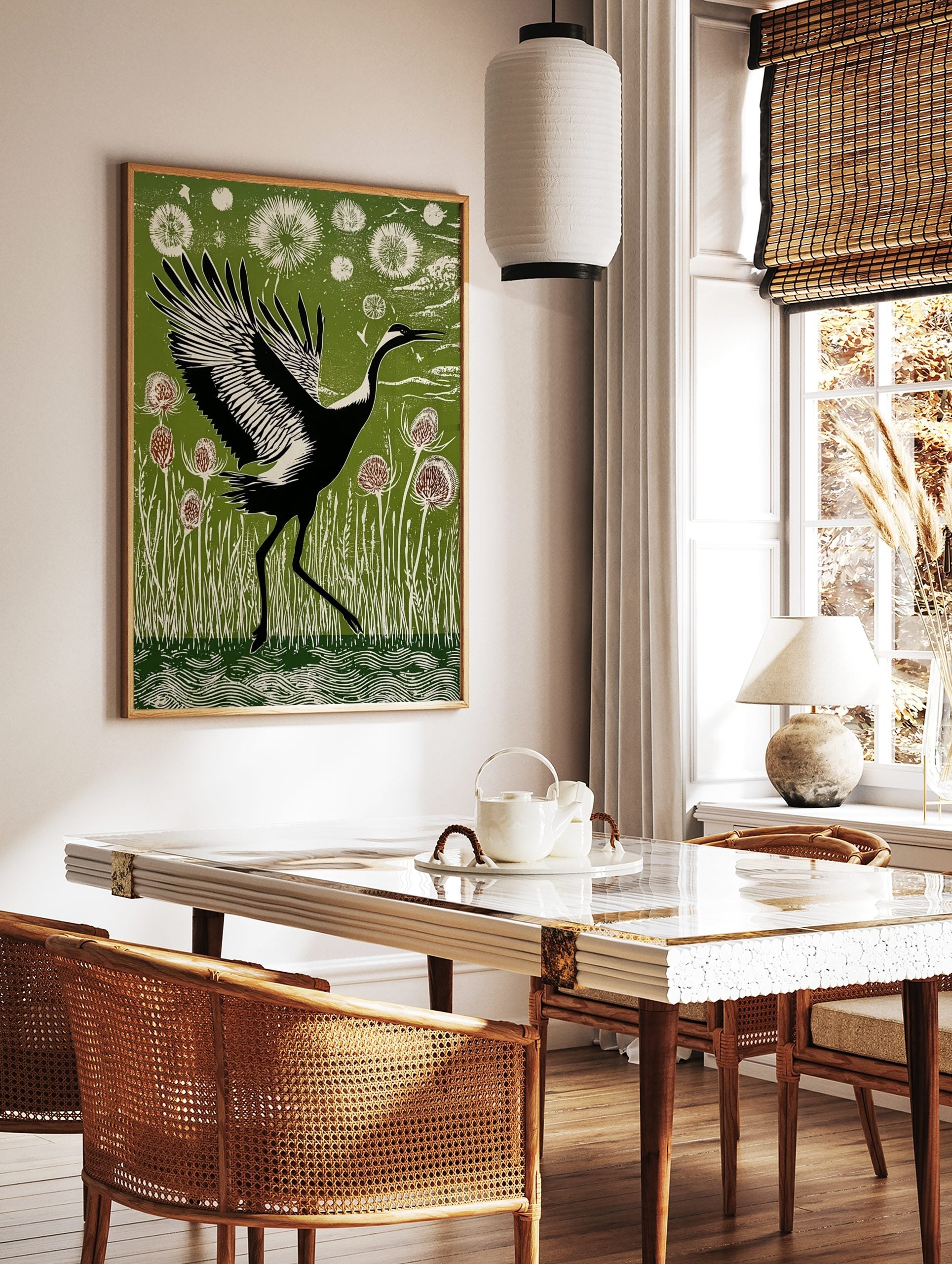 Black and white crane with widespread wings walking through green reeds and thistle plants in, in a styled room mockup