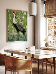 Linocut-style art print of a black and white crane with red head patch in green wetland with white, in a styled room mockup