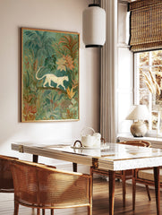 Illustrative wall art of a cream big cat walking on a branch amidst lush green and peach tropical, in a styled room mockup