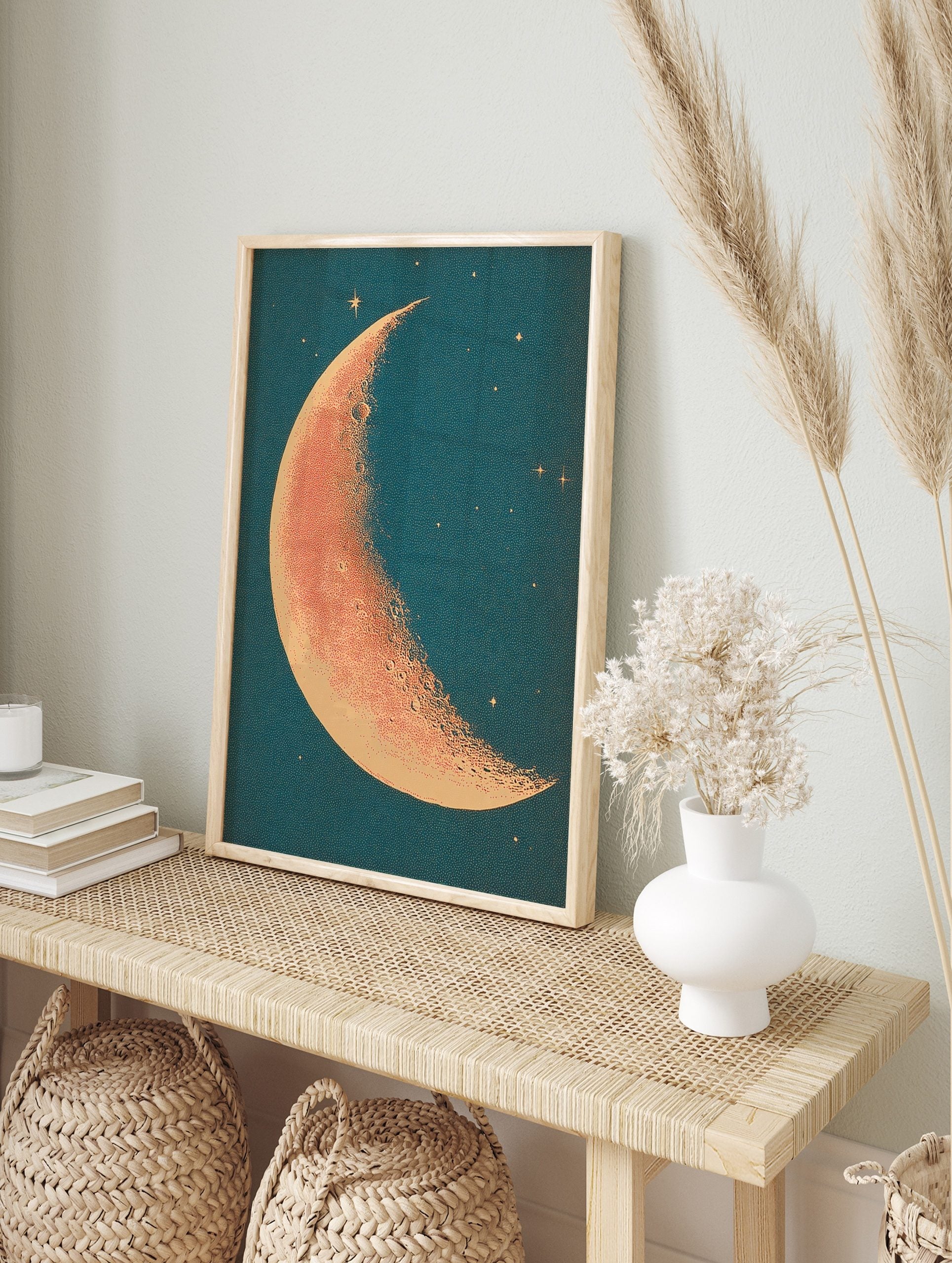 Crescent moon illustration with stippled orange-red surface and cream edge against a deep, in an alternate framed mockup