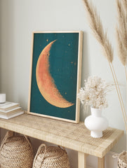 Crescent moon illustration with stippled orange-red surface and cream edge against a deep, in an alternate framed mockup