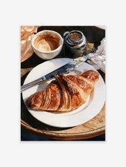 Watercolor painting of a croissant on a plate with coffee and a butter knife on a wooden table surface