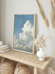 Realistic painting of fluffy white cumulus clouds against a bright blue sky, with subtle grey, in an alternate framed mockup