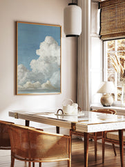 Realistic painting of fluffy white cumulus clouds against a bright blue sky, with subtle grey, in a styled room mockup