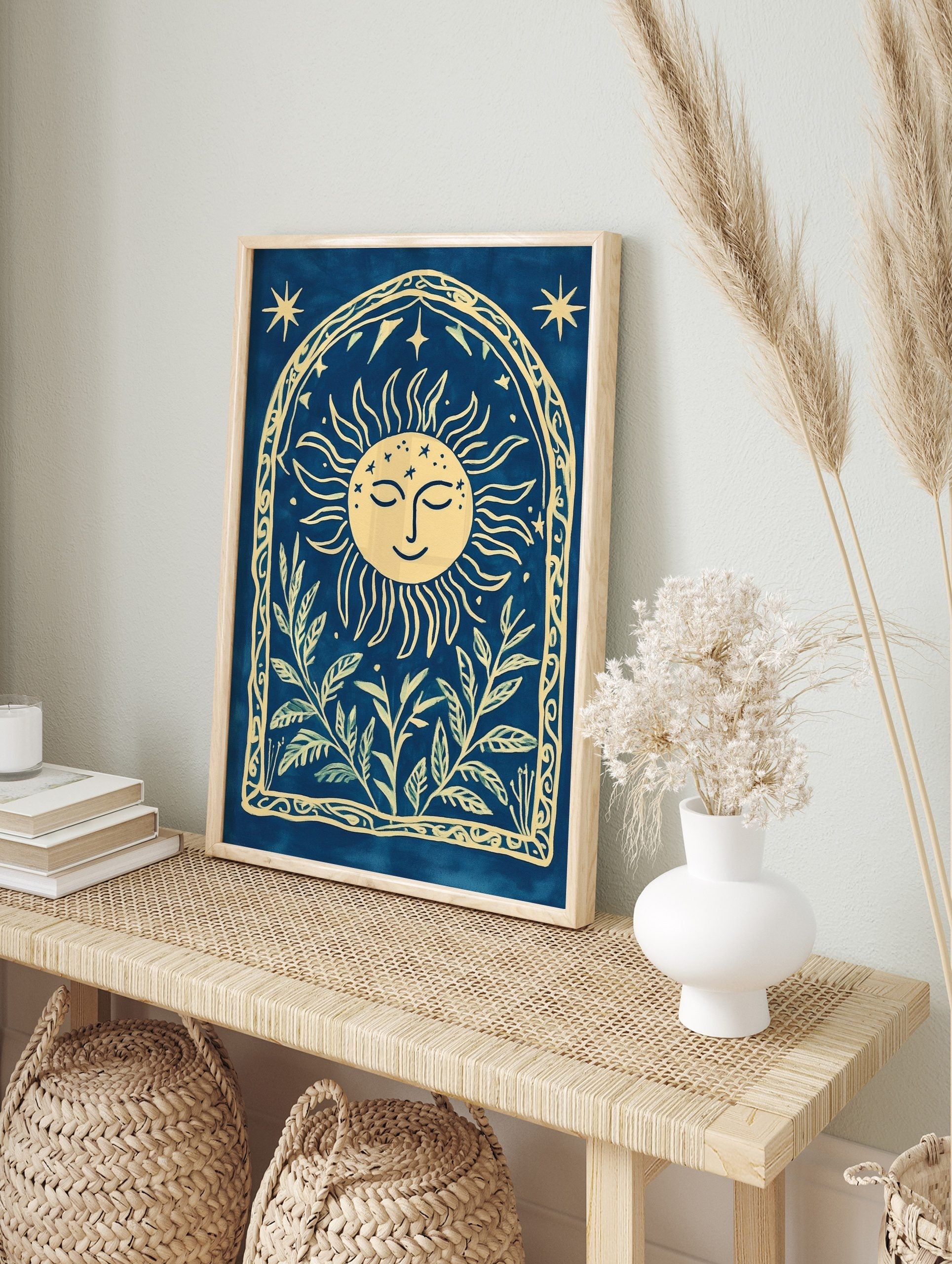 Cyanotype-style wall art with smiling sun, stars, and botanical leaves within an arched, in an alternate framed mockup