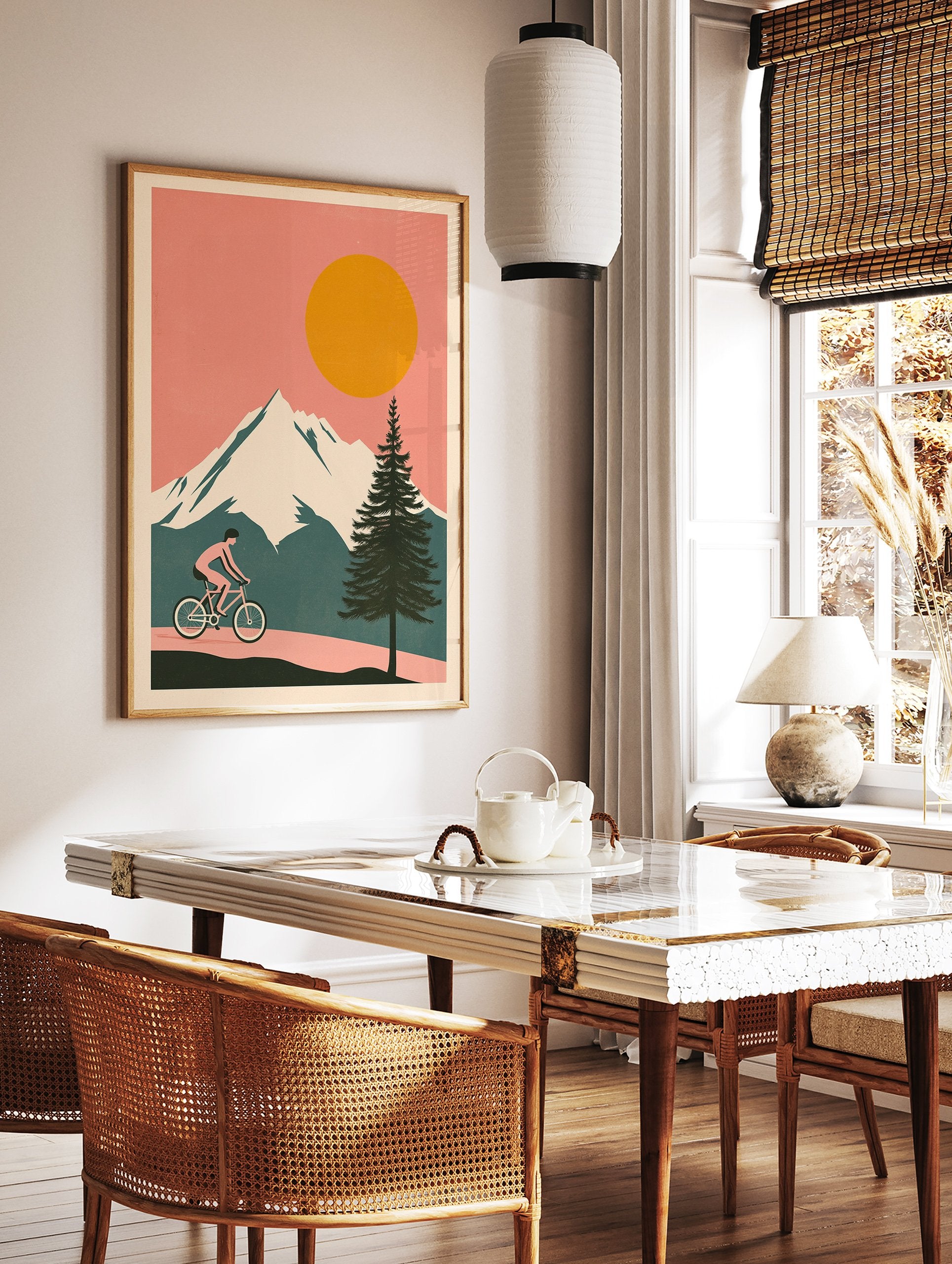 Cycling wall art illustration of a person riding a bicycle on a path with snowy mountains, a large orange sun, and a pine tree. - Image 2