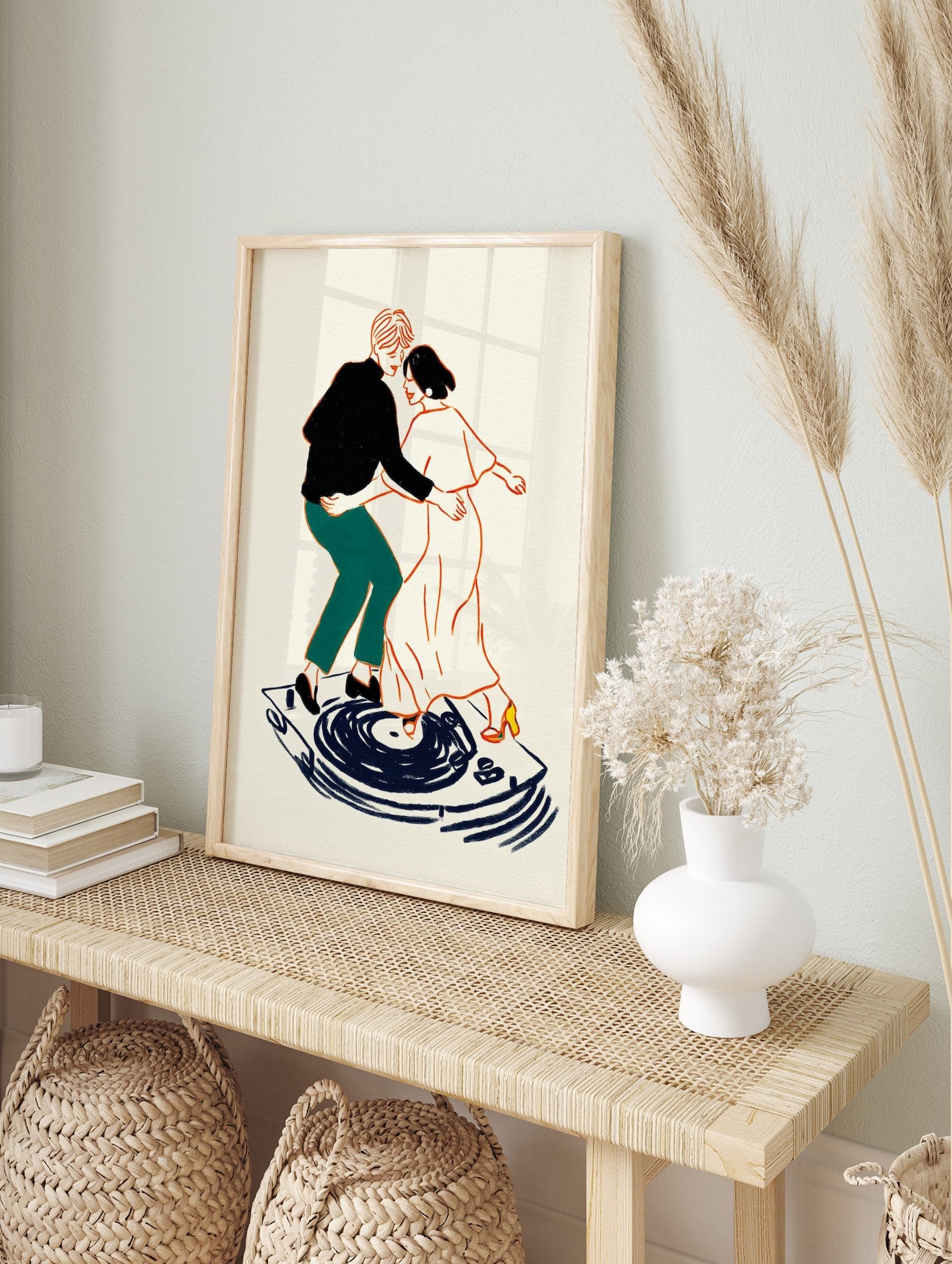 Illustrative art print of a couple dancing on a record player, outlined in orange with black, in an alternate framed mockup
