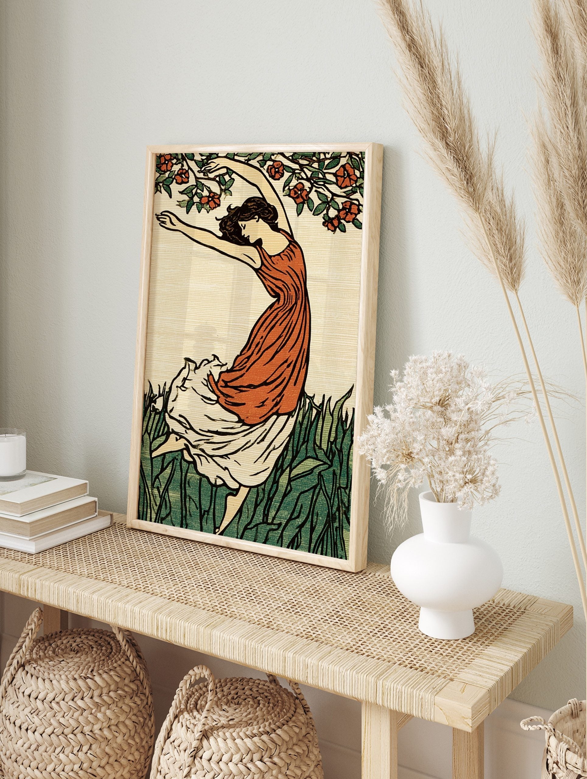 Art Nouveau illustration of a dancing woman in orange dress with green grass and red flowers, in an alternate framed mockup