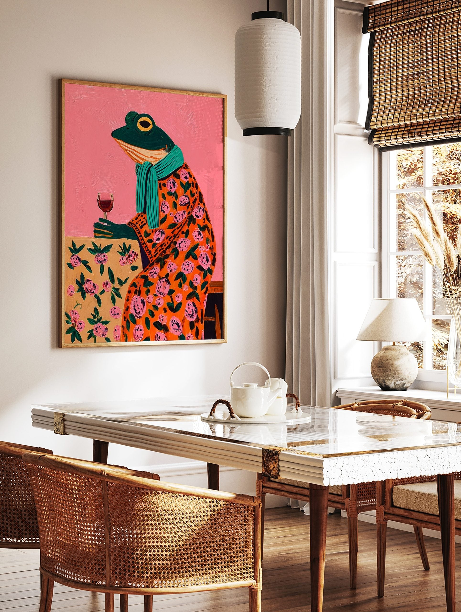 Whimsical painting of a frog in an orange floral robe, teal scarf, holding a wine glass against a, in a styled room mockup