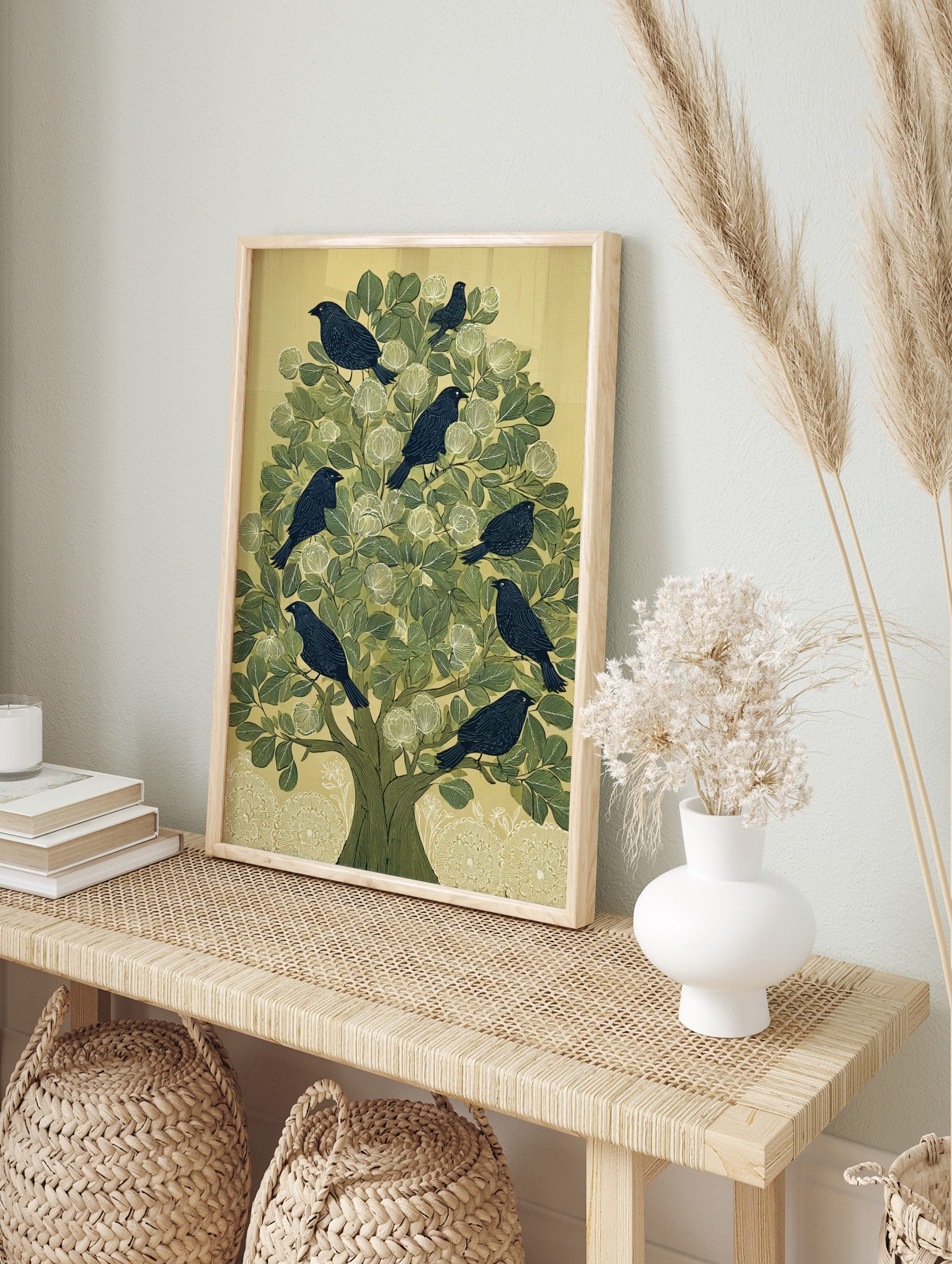 Illustrative print of dark birds in a green tree with white flowers and a pale background, in an alternate framed mockup