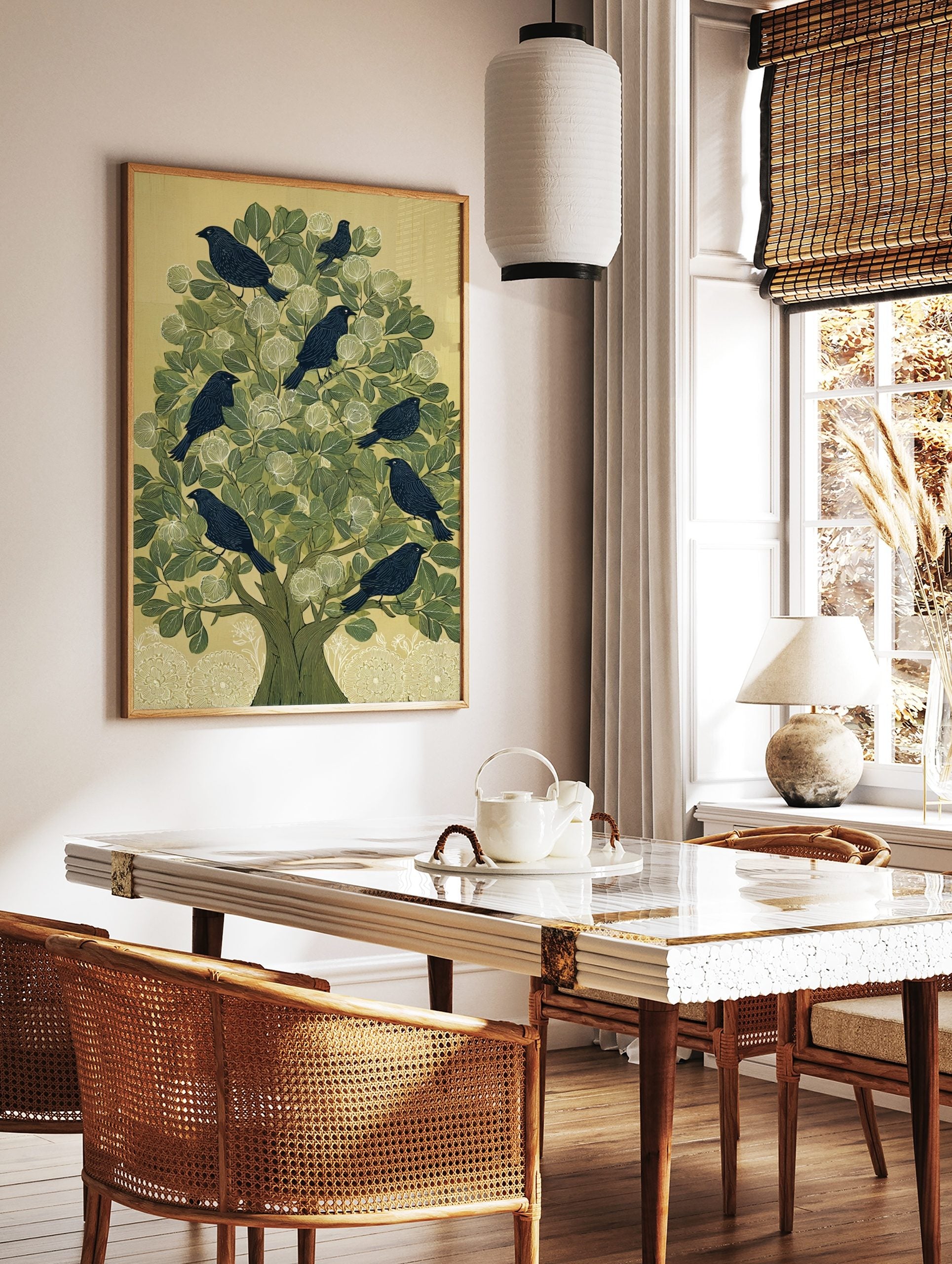 Illustrative print of dark birds in a green tree with white flowers and a pale background, portrait, in a styled room mockup