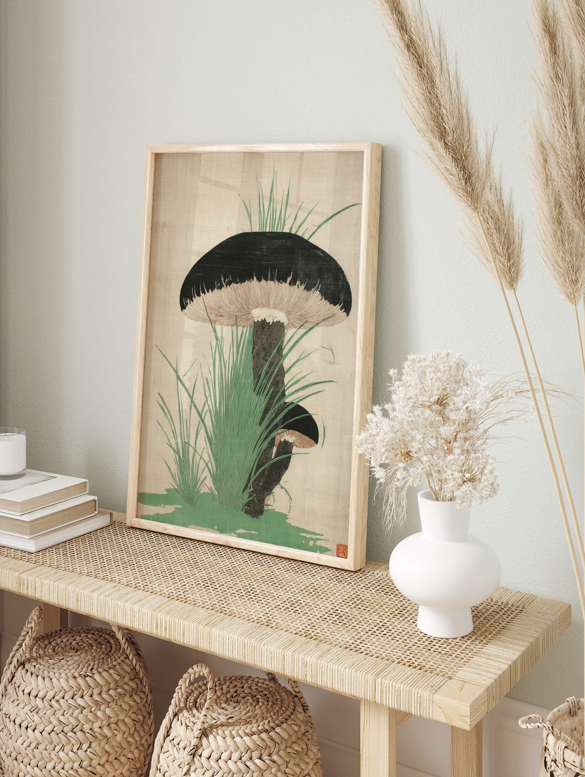 Botanical illustration of two dark-capped mushrooms with gills and green grass on a light, in an alternate framed mockup