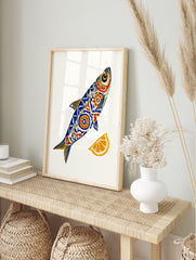 Stylised fish illustration with blue and orange geometric patterns and a lemon slice on a, in an alternate framed mockup