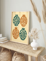 Four decorative round vases in teal and orange with swirling botanical patterns on a light, in an alternate framed mockup