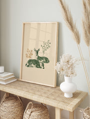 Illustrative print of two green deer fawns resting, with brown and green foliage on a light, in an alternate framed mockup