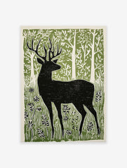 Black deer silhouette linocut print in a green forest with white trees and foliage, on a light background.