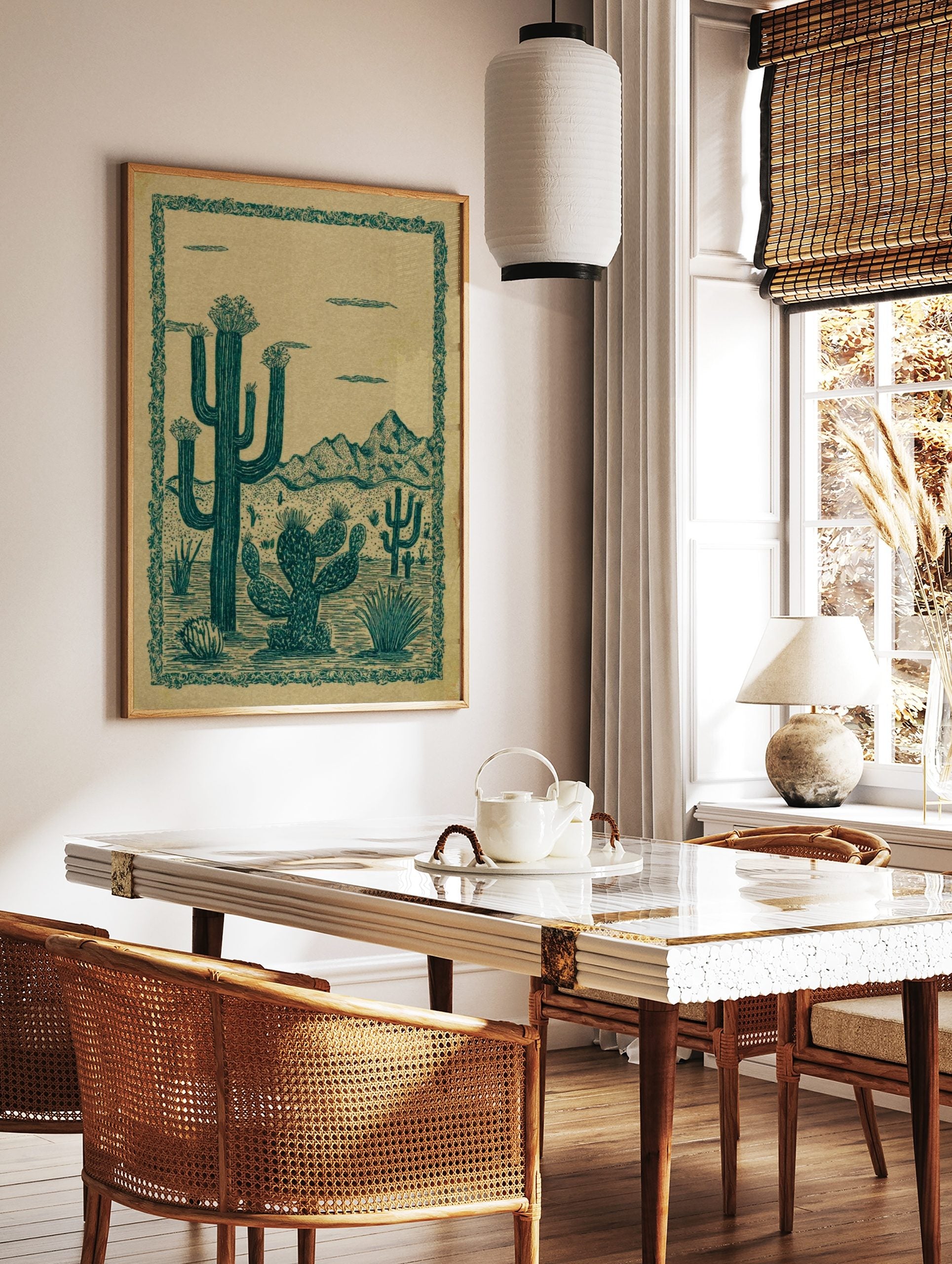 Illustrative desert landscape print with teal green saguaro and prickly pear cacti against a tan, in a styled room mockup