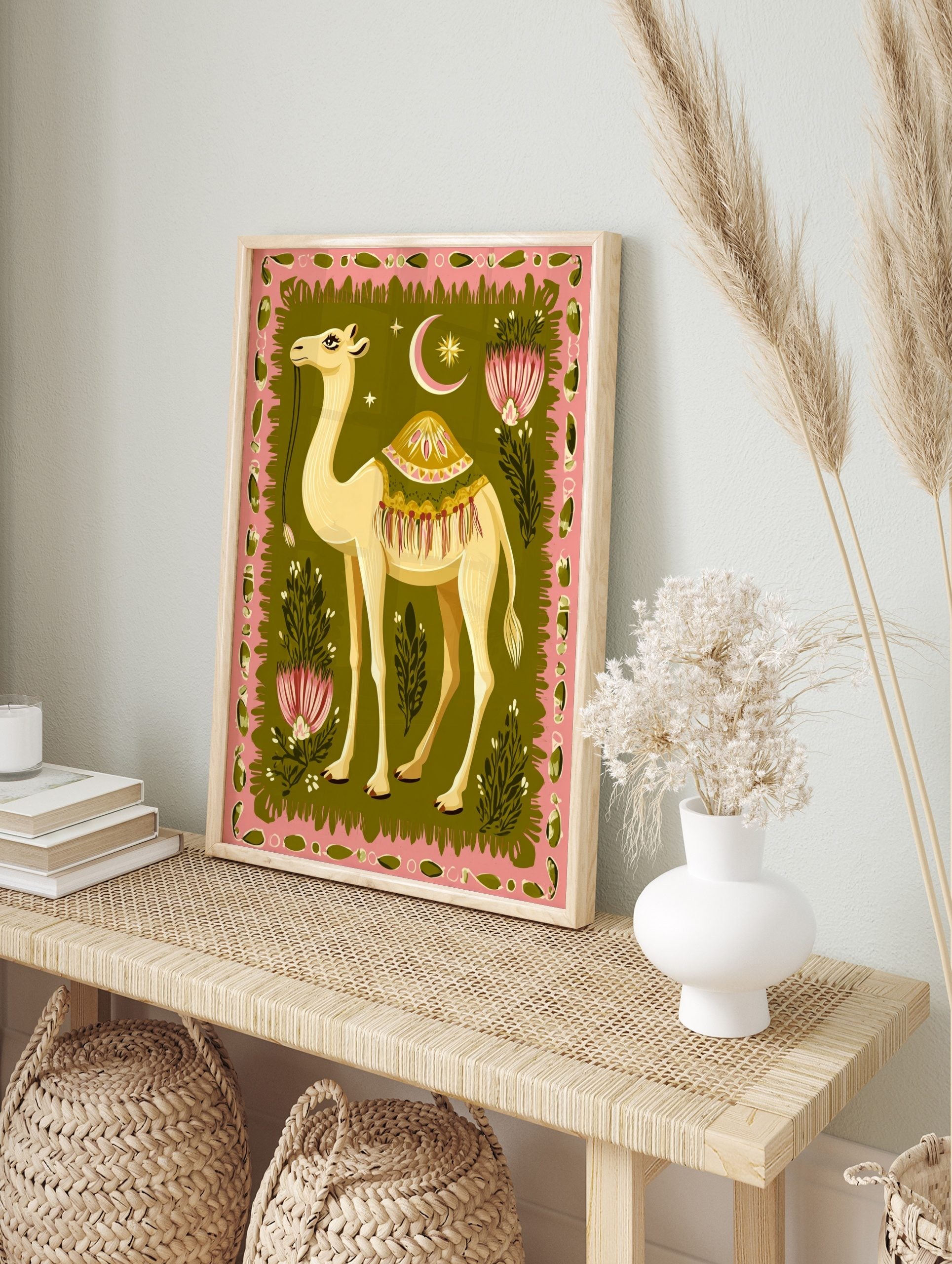 Illustrative camel wall art with ornate saddle, pink border, green background, stylised, in an alternate framed mockup