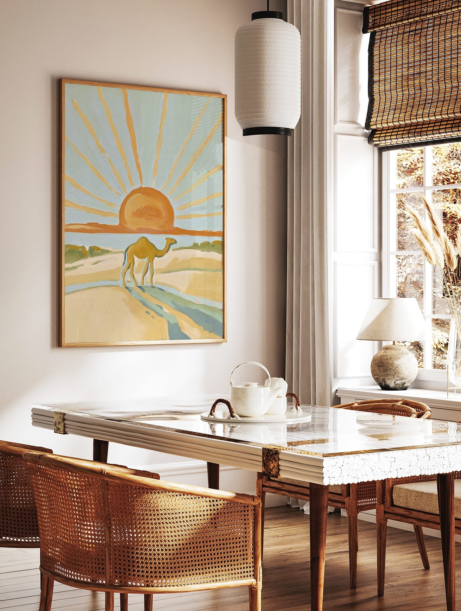 Illustrative desert scene with a camel walking on sand dunes under a large orange sun with golden, in a styled room mockup