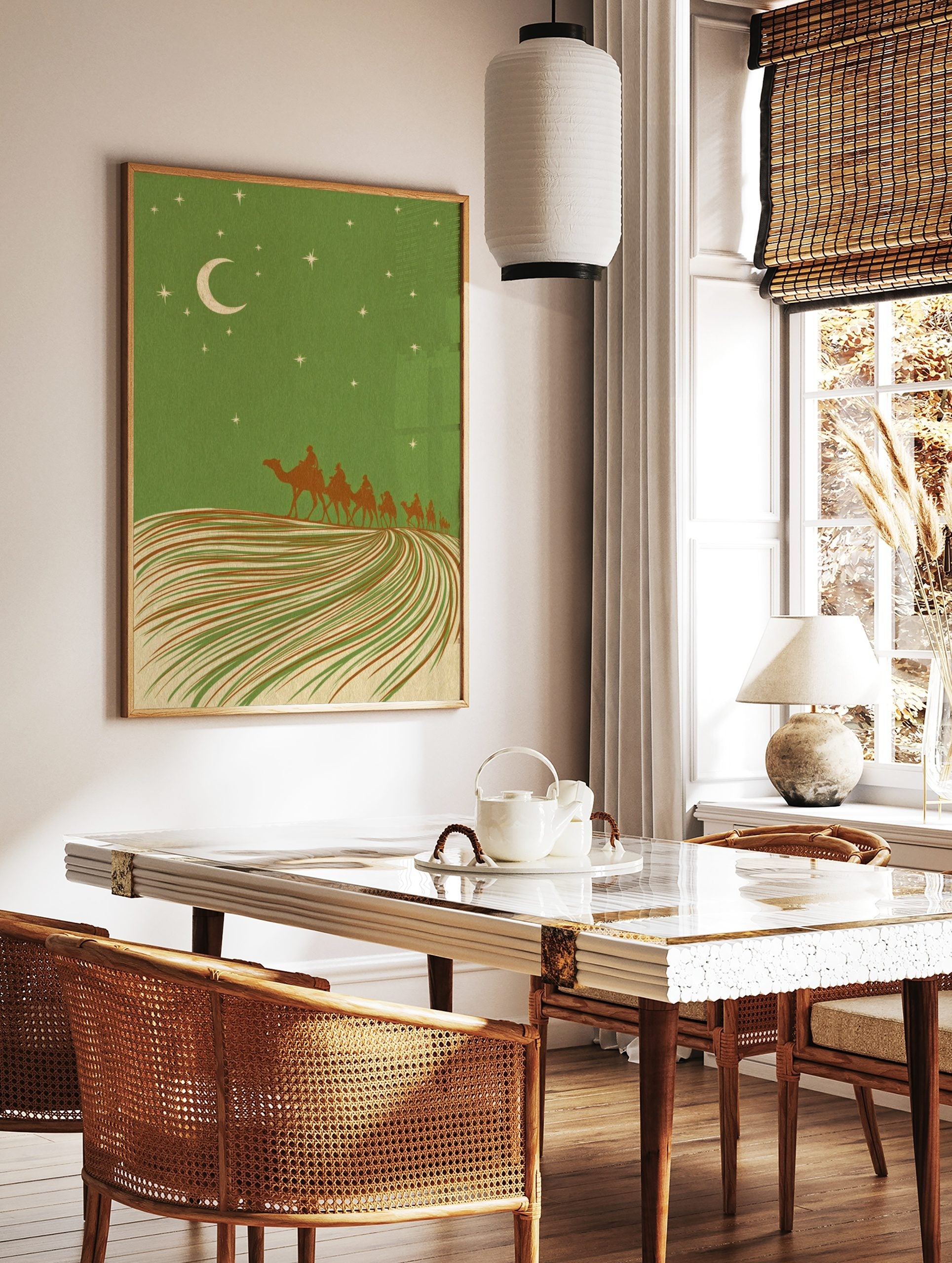 Illustrative desert night scene with camel caravan, crescent moon, and stars against a green sky, in a styled room mockup