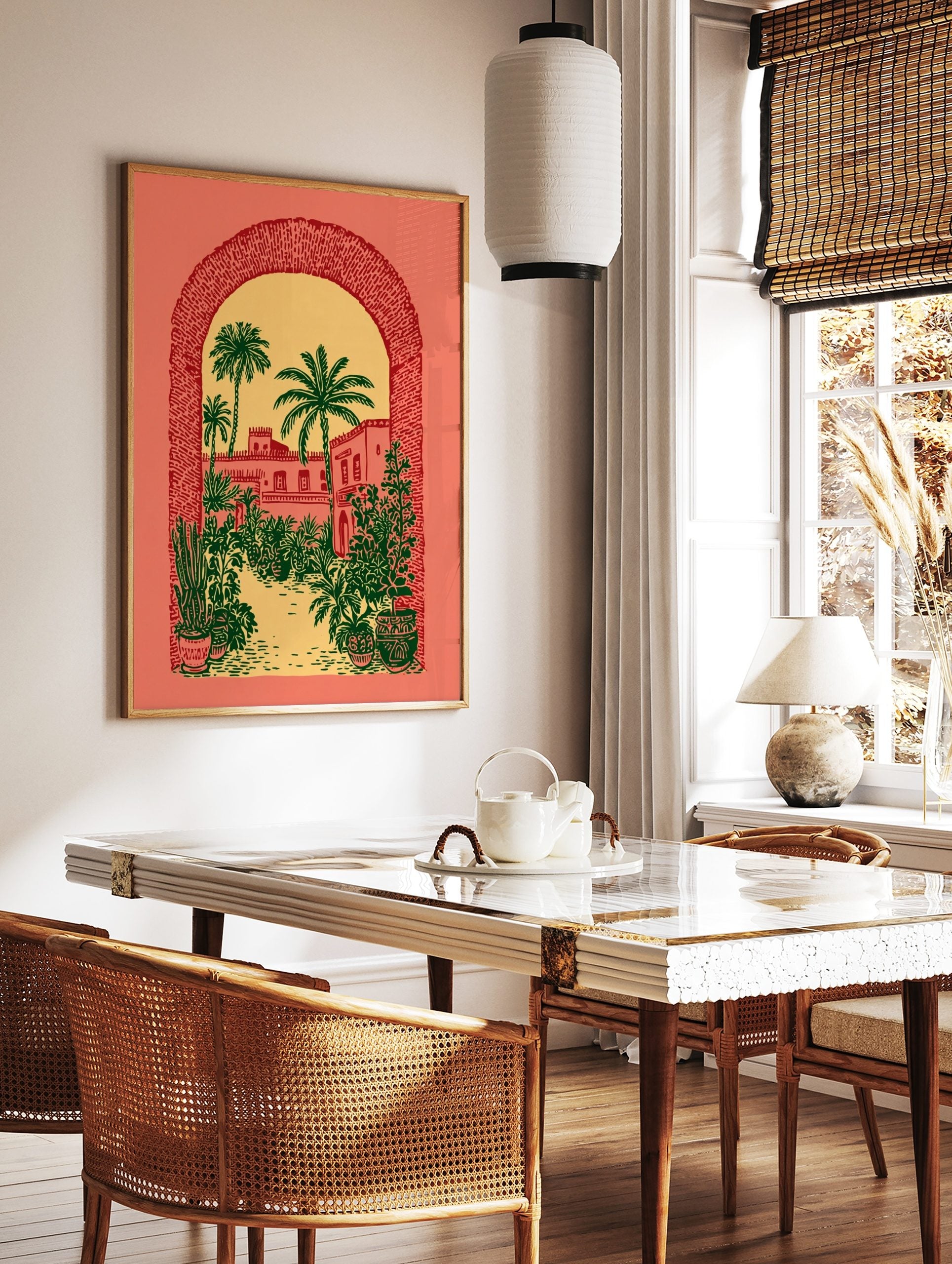 Illustrative print of a desert courtyard with palm trees and buildings, viewed through a textured, in a styled room mockup