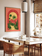 Illustrative print of a desert courtyard with palm trees and buildings, viewed through a textured, in a styled room mockup