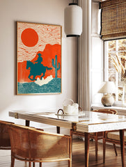 Illustrative Western art print of cowboy on horse against orange sun and desert landscape with, in a styled room mockup