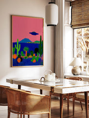 Surreal desert landscape poster with a pink sky, blue ocean, green cacti, and a dark blue UFO flying above a small town. - Image 2