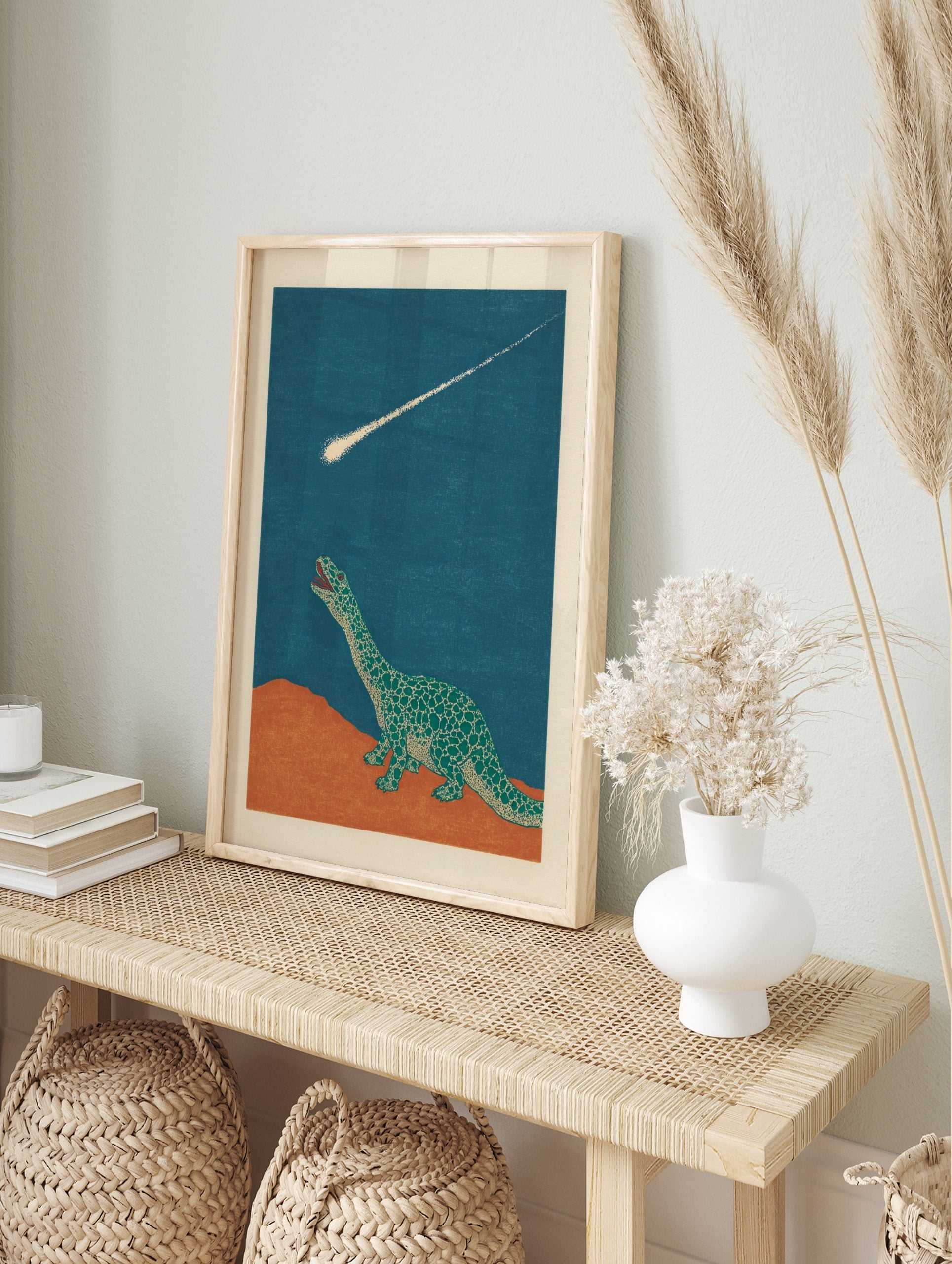 Illustrative green dinosaur looking up at a bright meteor streaking across a dark blue sky, in an alternate framed mockup