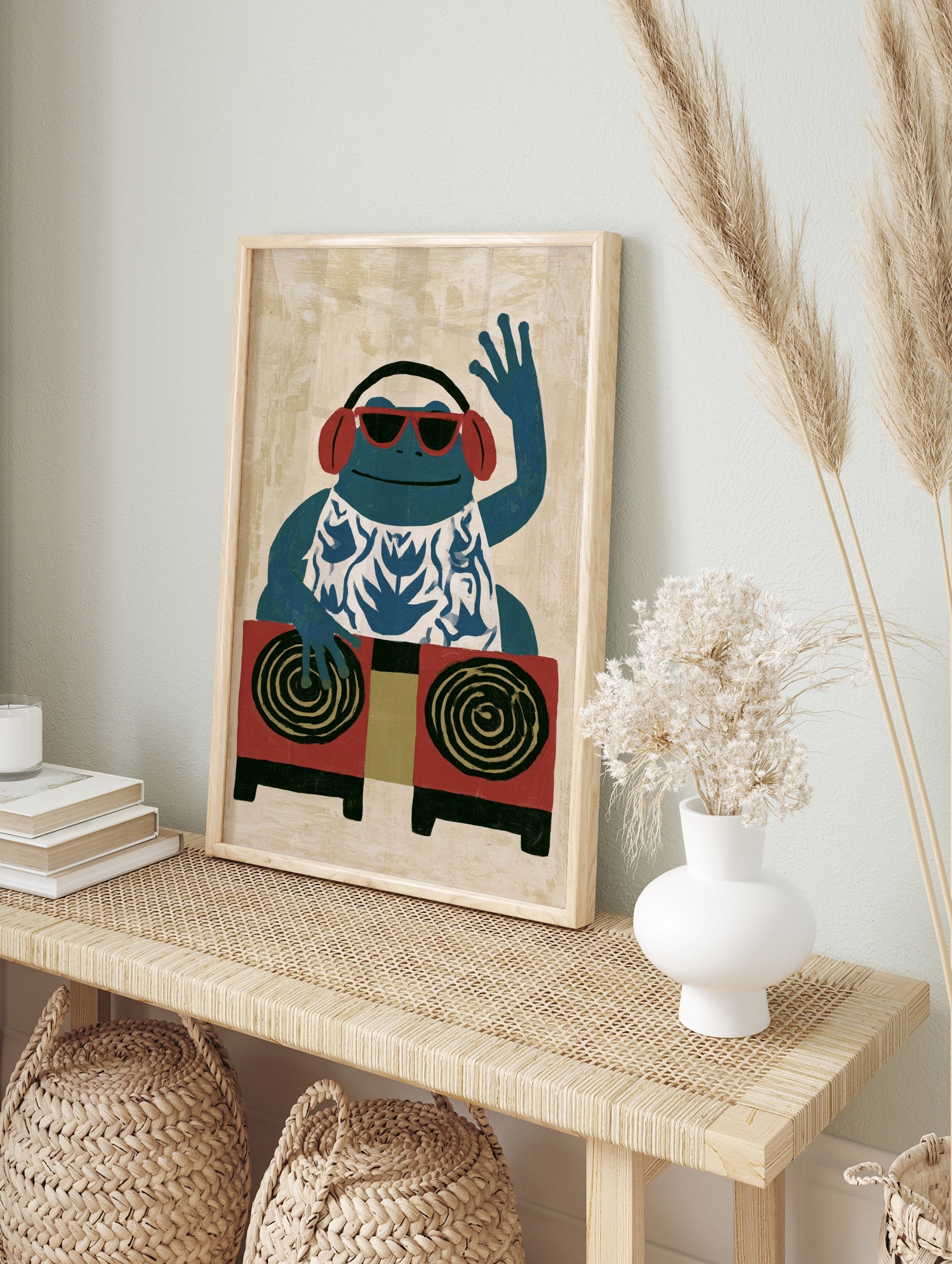 Illustrative blue frog DJ art print wearing red sunglasses and headphones, in an alternate framed mockup