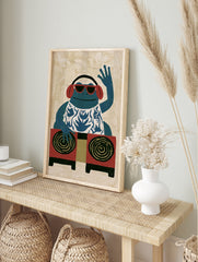 Illustrative blue frog DJ art print wearing red sunglasses and headphones, in an alternate framed mockup