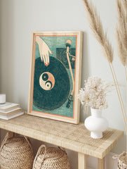 Illustrative print of a hand with red nails over a vinyl record with a Yin Yang symbol on a, in an alternate framed mockup