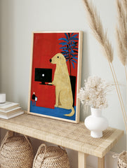 Illustrative art print of a yellow dog at a computer desk against a red background with a, in an alternate framed mockup