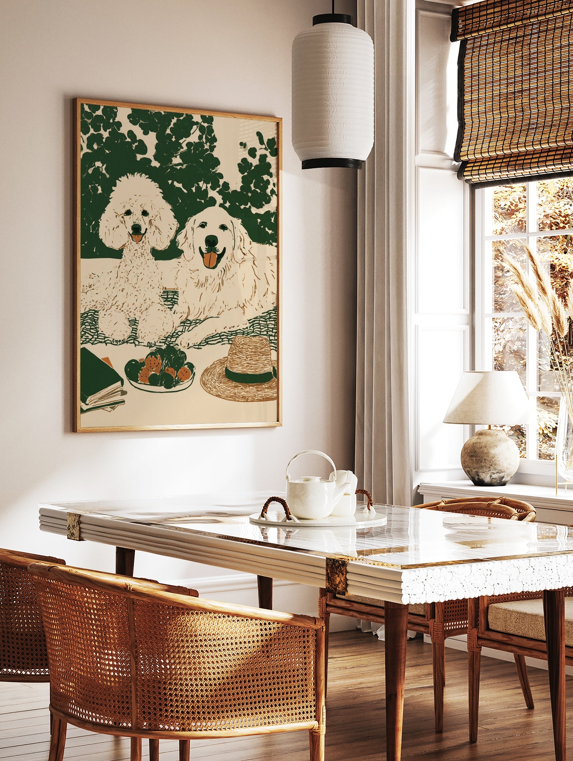 Illustrated wall art of a poodle and golden retriever on a picnic blanket with strawberries, a hat, in a styled room mockup