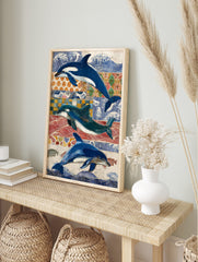 Three blue and white dolphins and orcas swimming against a collage of blue, red, and orange, in an alternate framed mockup