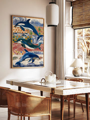 Three blue and white dolphins and orcas swimming against a collage of blue, red, and orange, in a styled room mockup