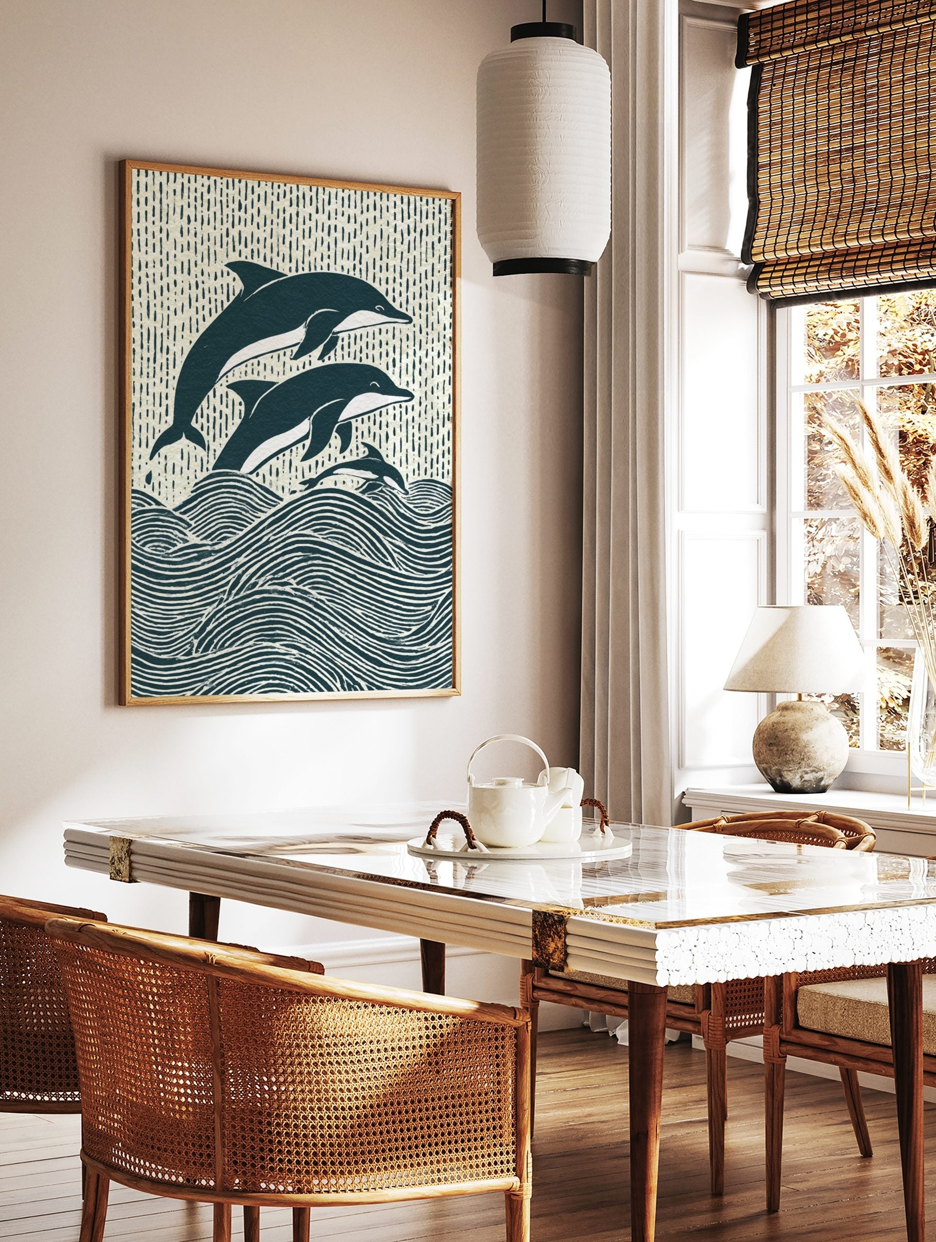 Illustrative woodcut-style print of three navy and white dolphins leaping from ocean waves, in a styled room mockup