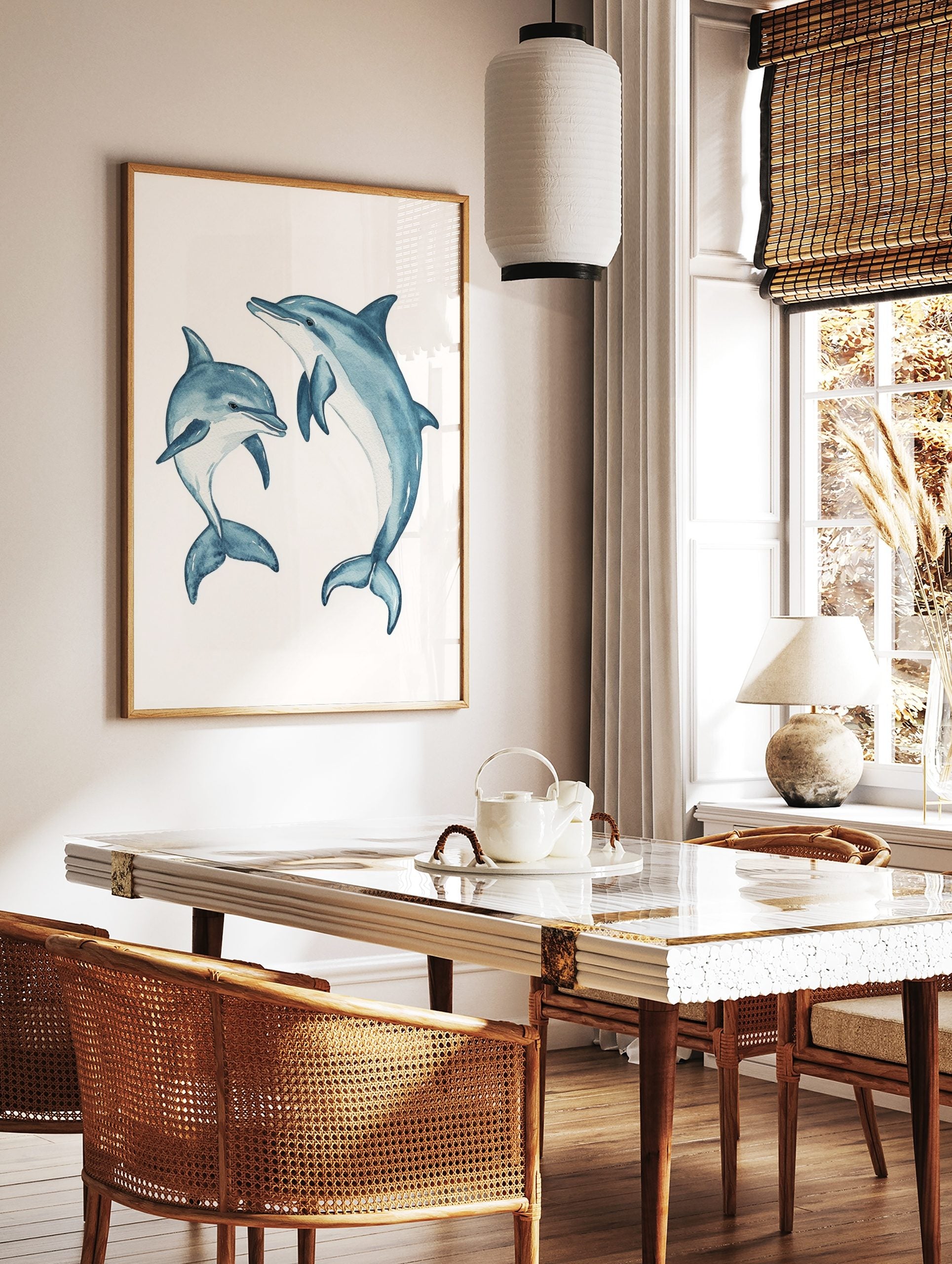 Two blue watercolour dolphins, one large and one small, in dynamic swimming poses on a white, in a styled room mockup
