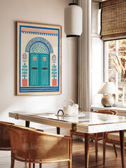 Illustrative doorway wall art print with an arched blue door, red accents, and potted plants on a cream background, folk art style. - Image 2