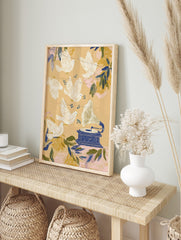 Illustrative art print with white doves flying around a blue gramophone and music notes on a, in an alternate framed mockup
