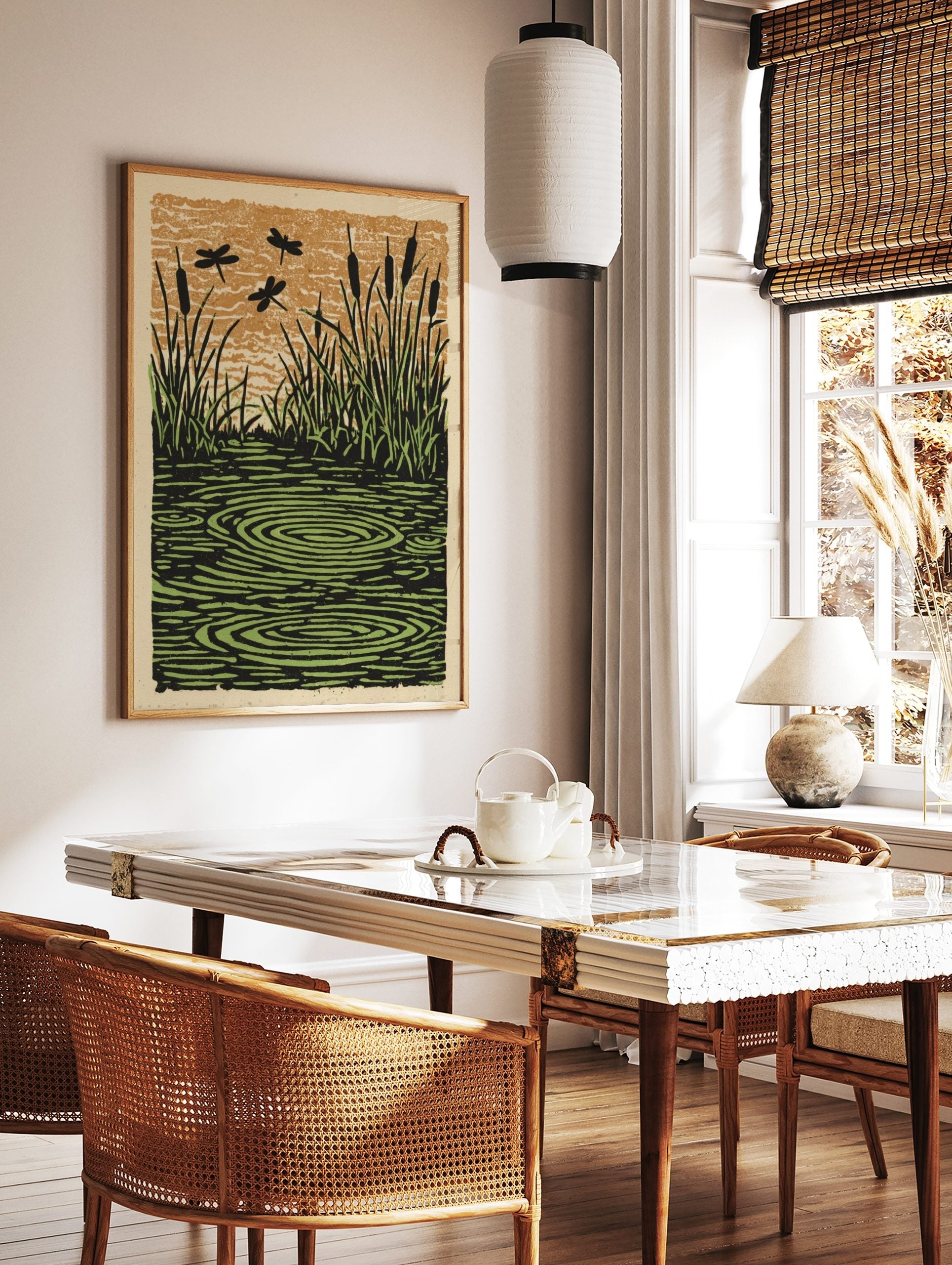 Illustrative print of dragonflies flying over a pond with cattails, grass, and water ripples in, in a styled room mockup