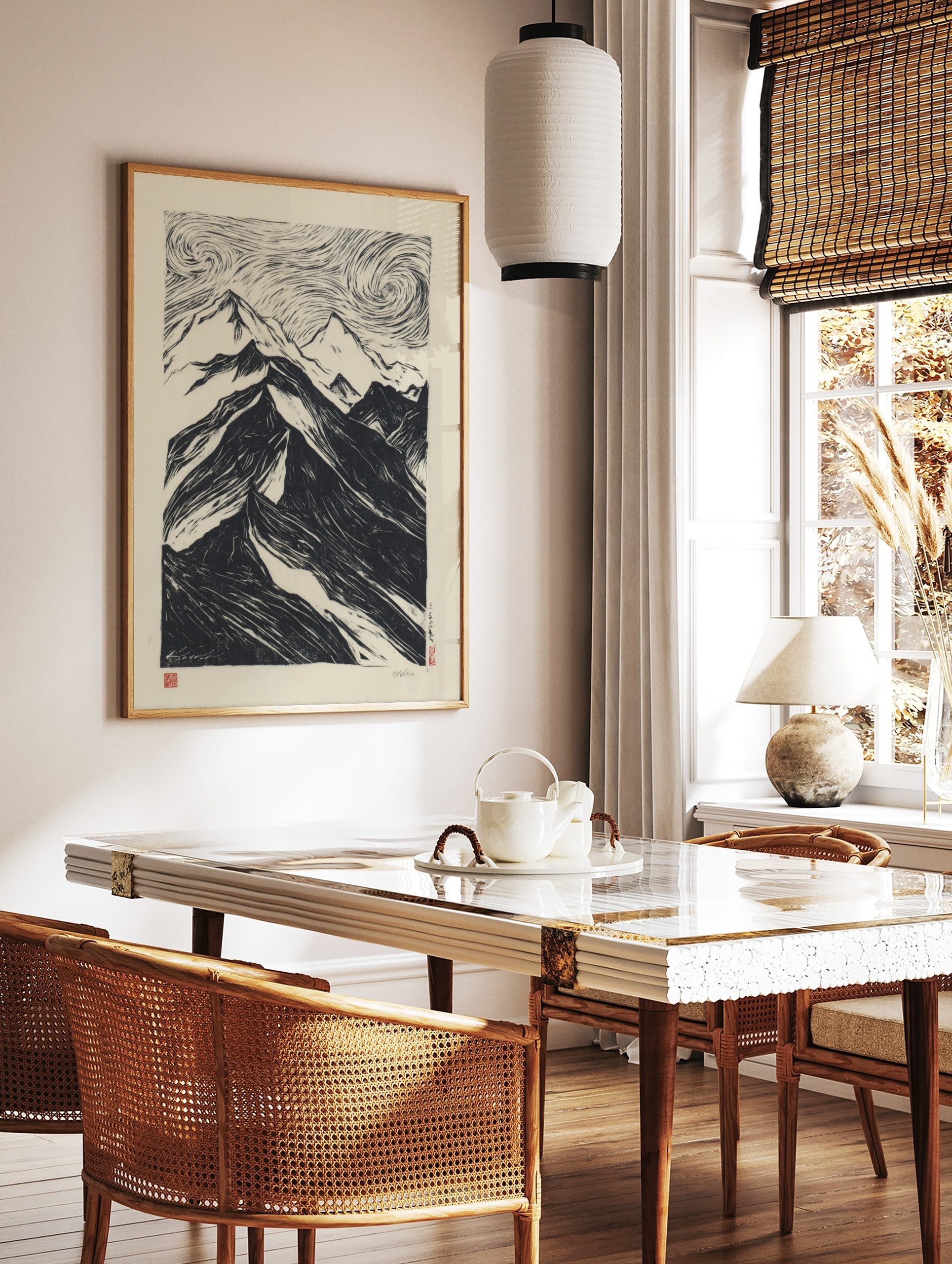 Black and white woodcut print of dramatic mountains under a swirling, textured sky in a bold, in a styled room mockup