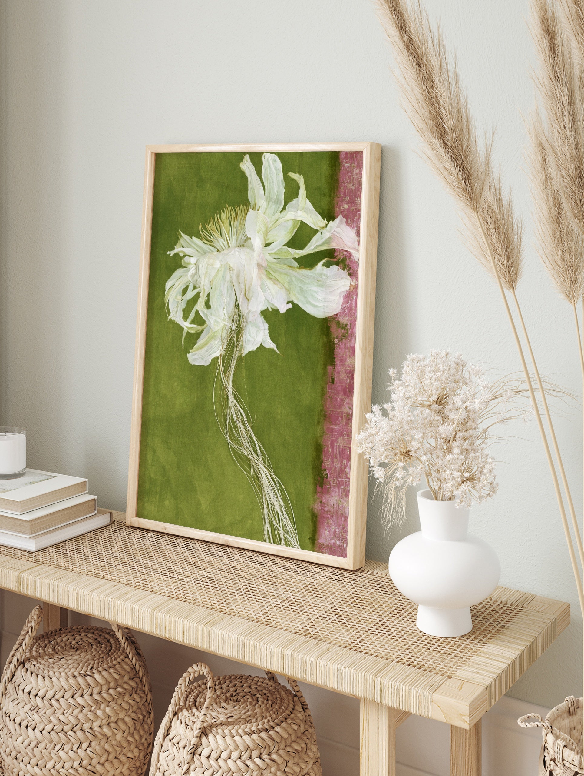 Dried white flower with trailing roots on a green background with a pink textured strip, in an alternate framed mockup