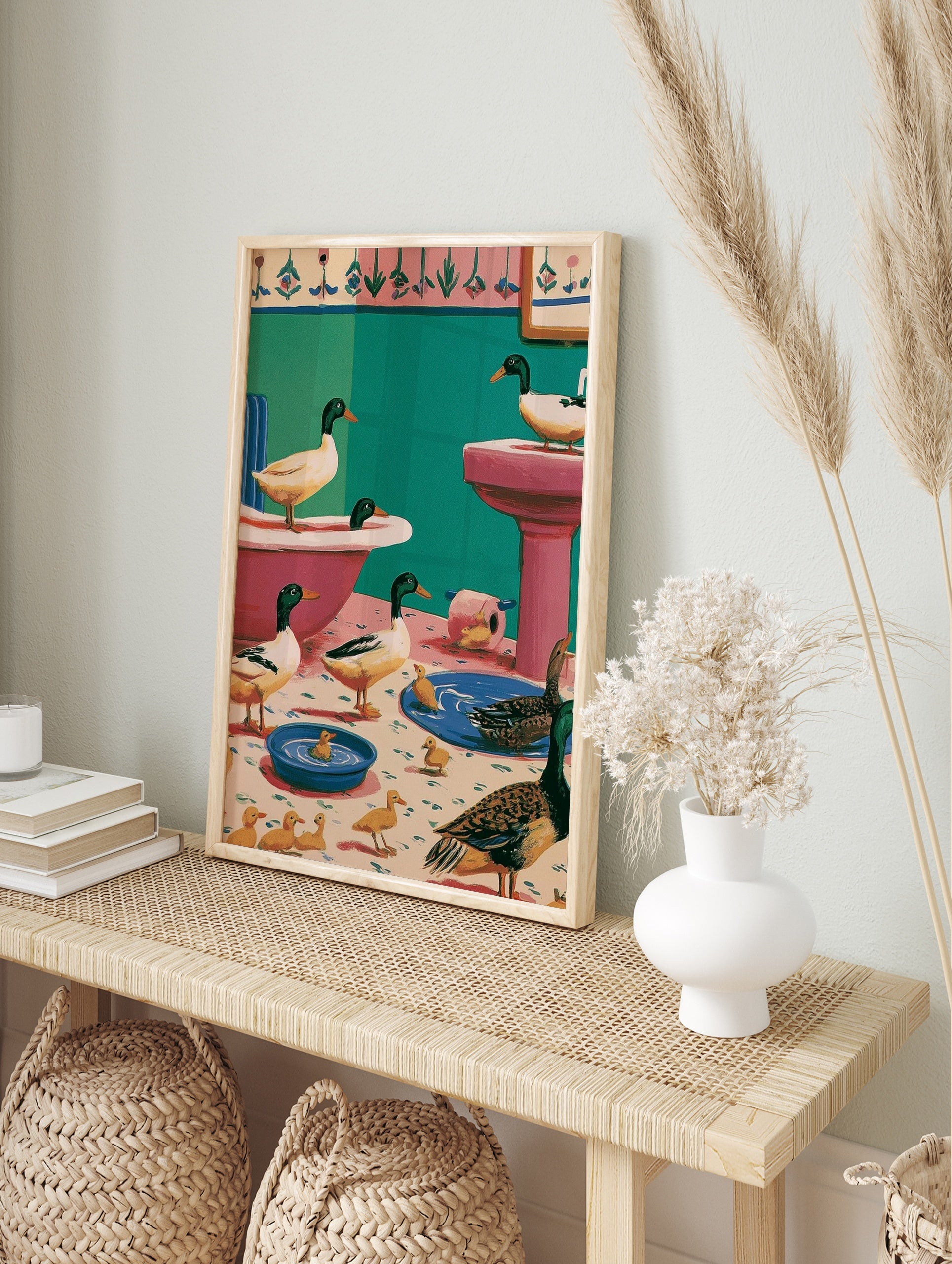 Whimsical illustration of mallard ducks and ducklings inside a pink and teal bathroom with, in an alternate framed mockup