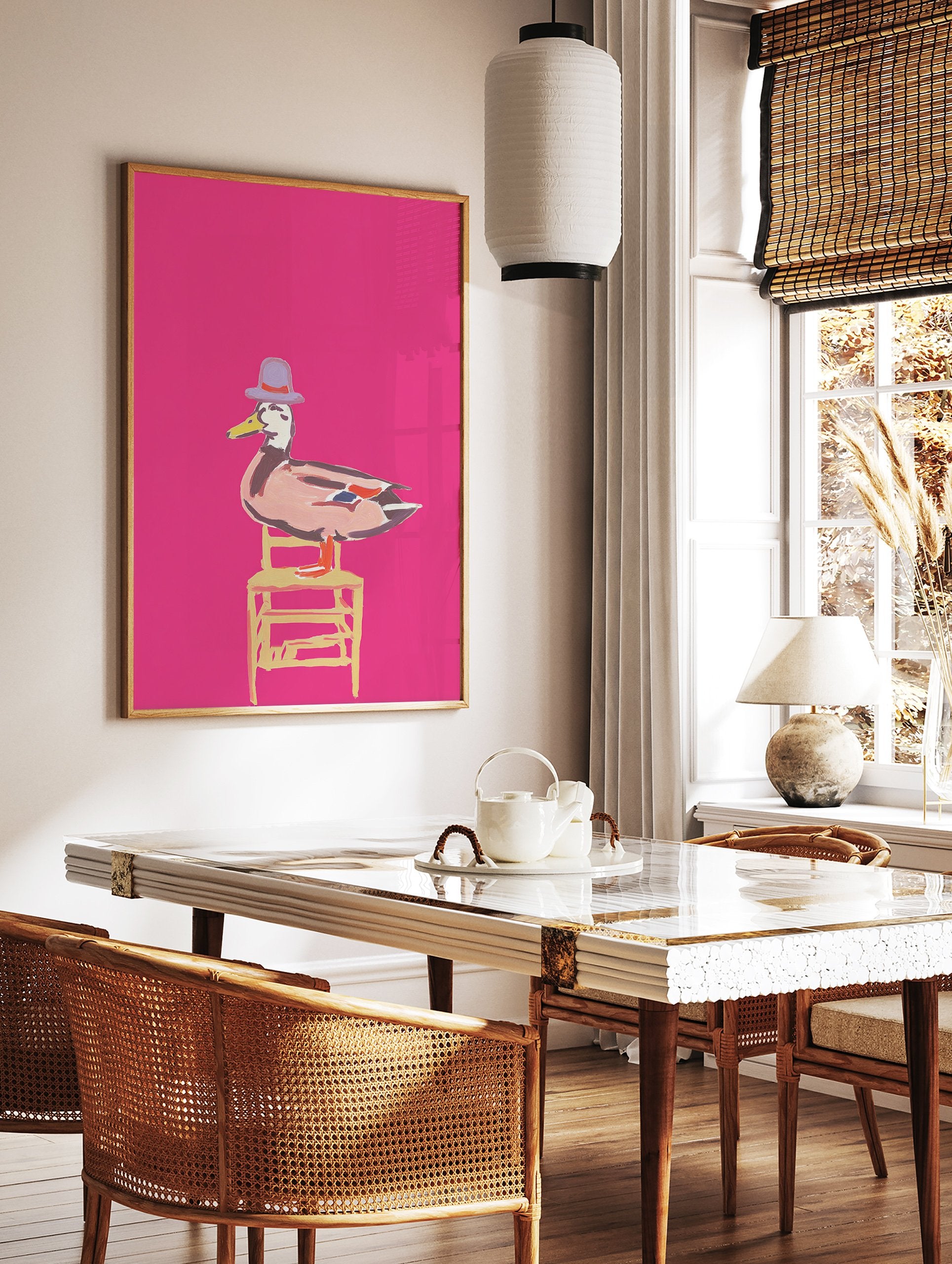 Whimsical duck wall art illustration wearing a purple hat and sitting on a yellow chair against a bright pink background. - Image 2