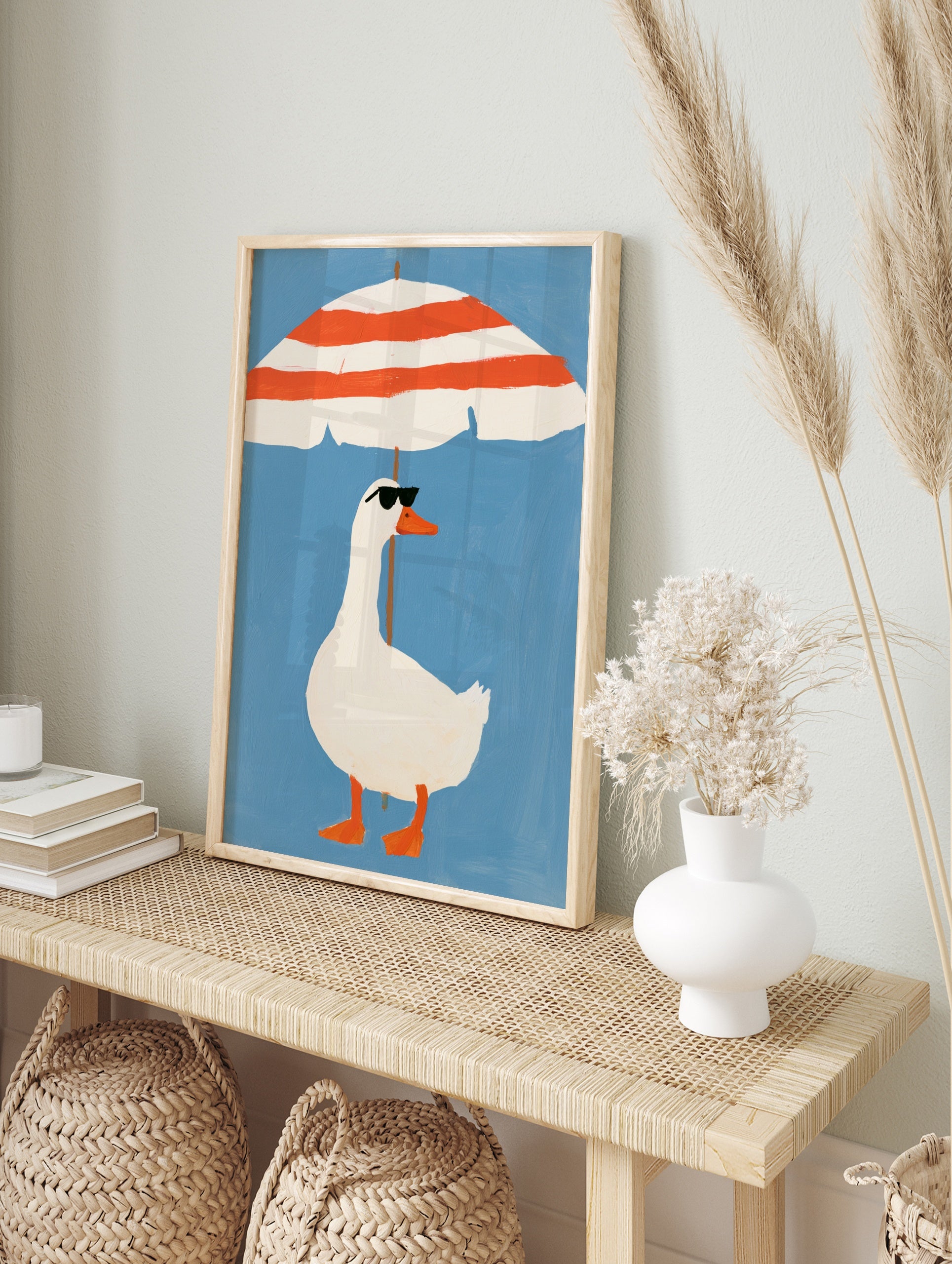 Illustration of a white duck in sunglasses standing under a red and white striped beach, in an alternate framed mockup