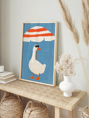 Illustration of a white duck in sunglasses standing under a red and white striped beach, in an alternate framed mockup