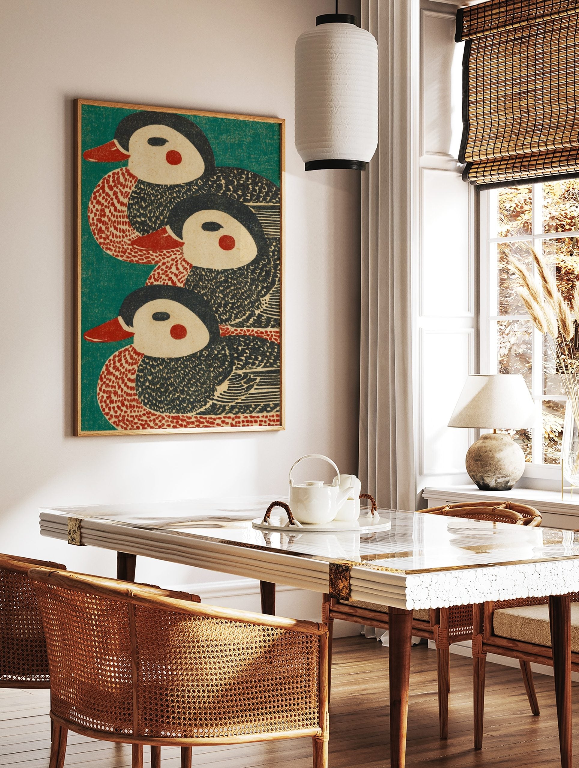 Three stylised duck illustrations with red beaks and cheeks on a teal background, in a woodblock, in a styled room mockup