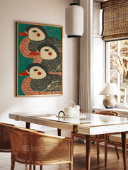 Three stylised duck illustrations with red beaks and cheeks on a teal background, in a woodblock, in a styled room mockup