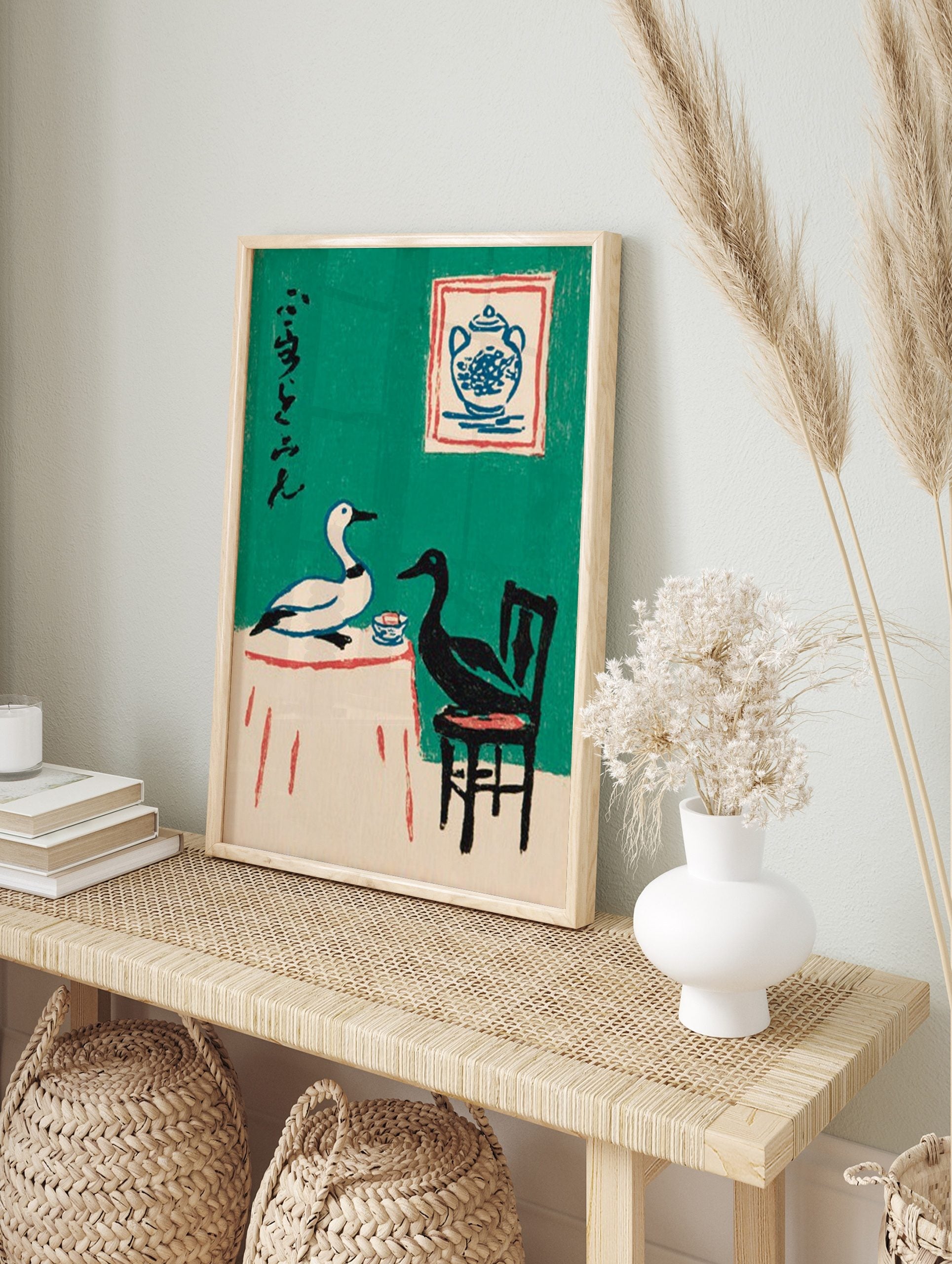 Illustrative art print of a white and black duck at a table with Japanese calligraphy on a, in an alternate framed mockup